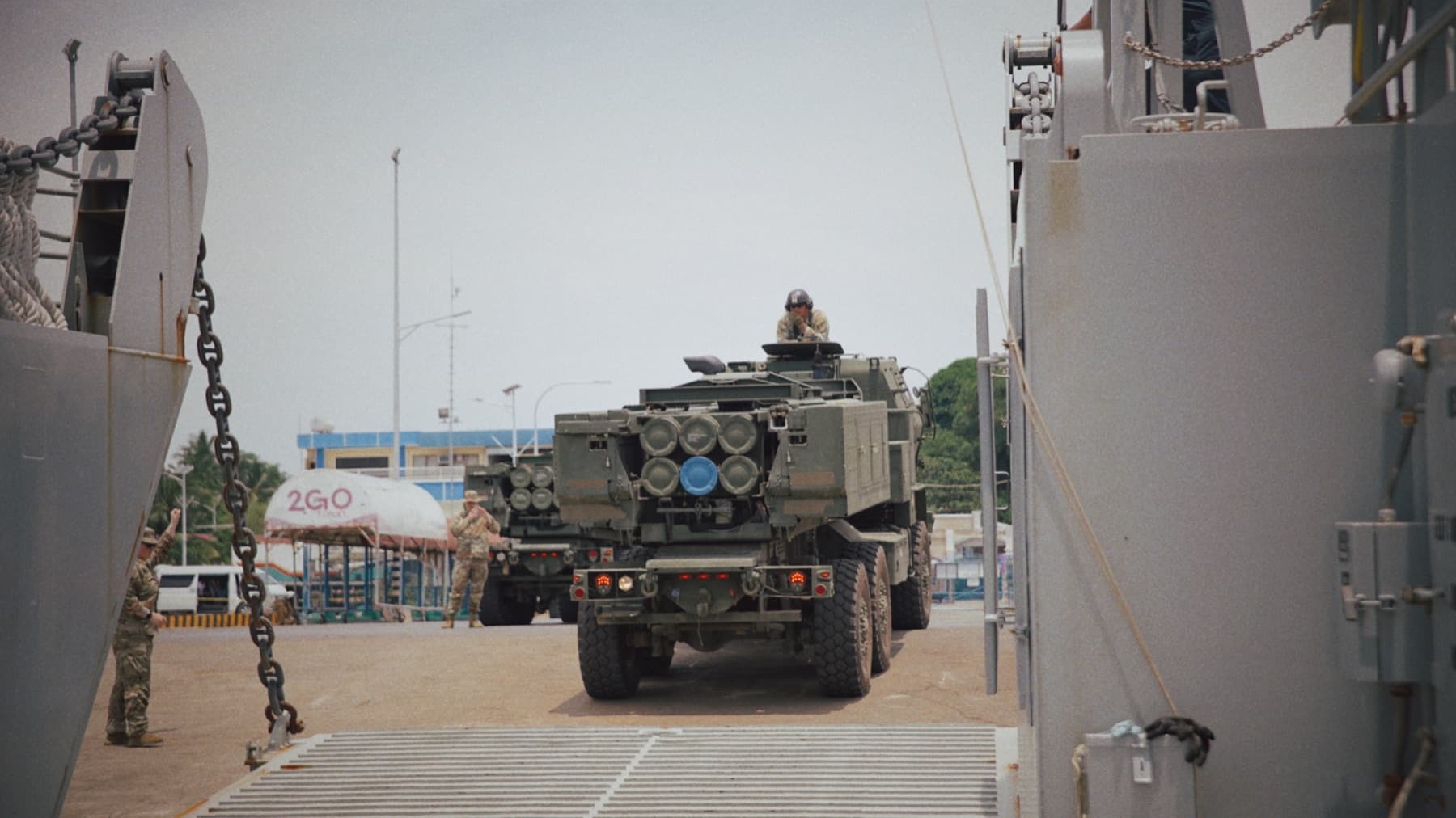 An armored vehicle driving onto an Army landing craft