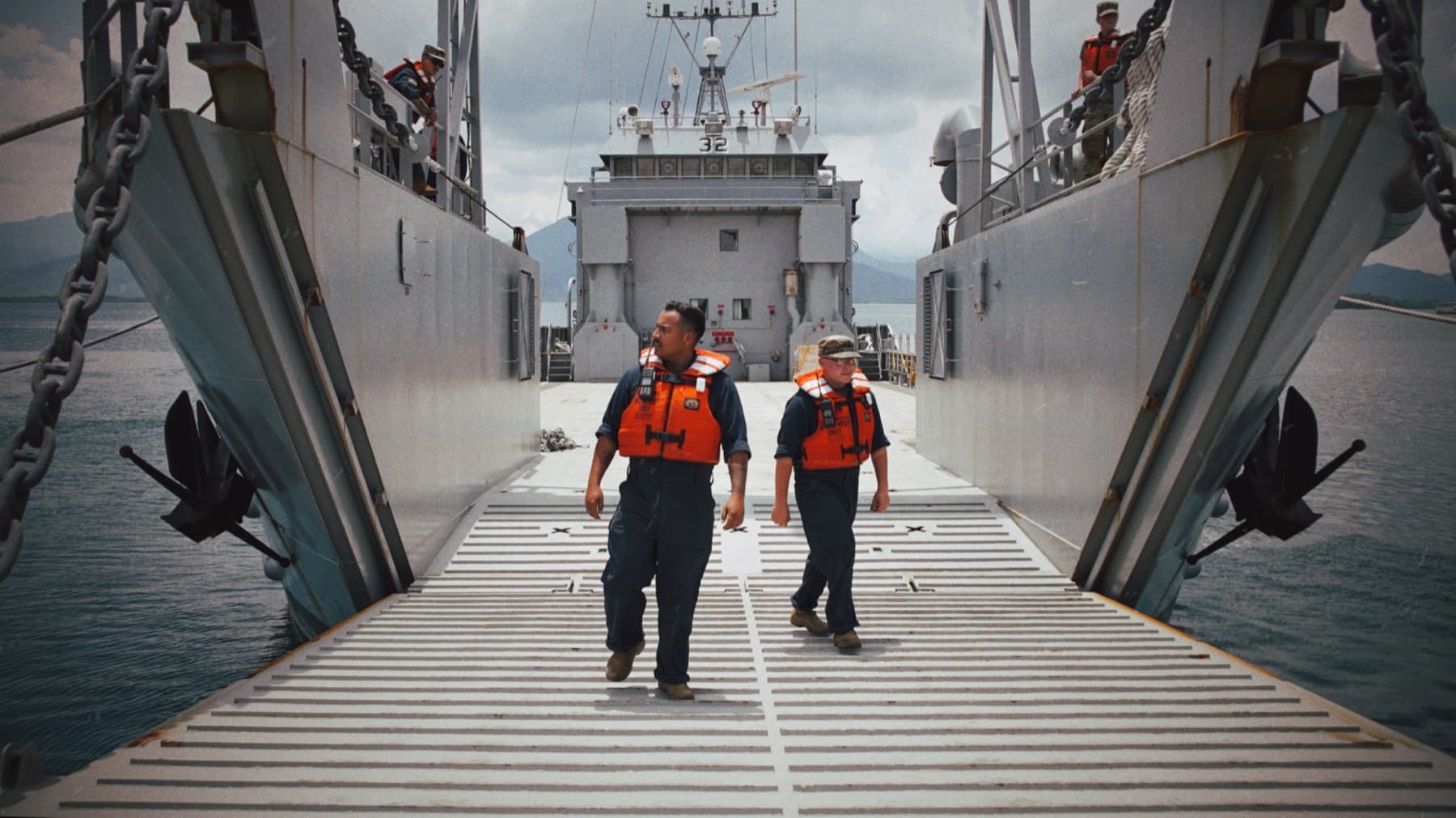Two crew members walking down a landing craft ramp