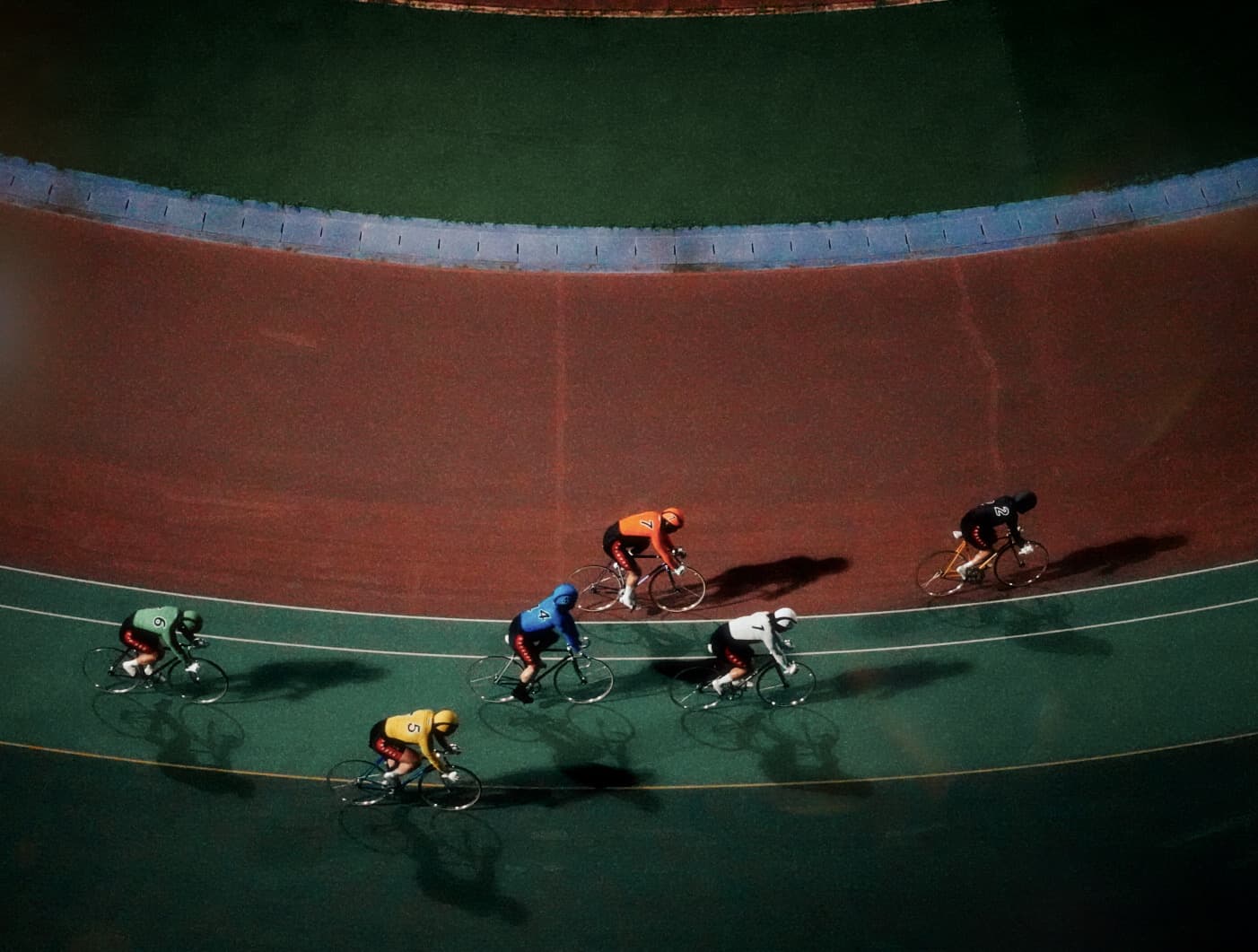 Cyclists racing on a velodrome at night