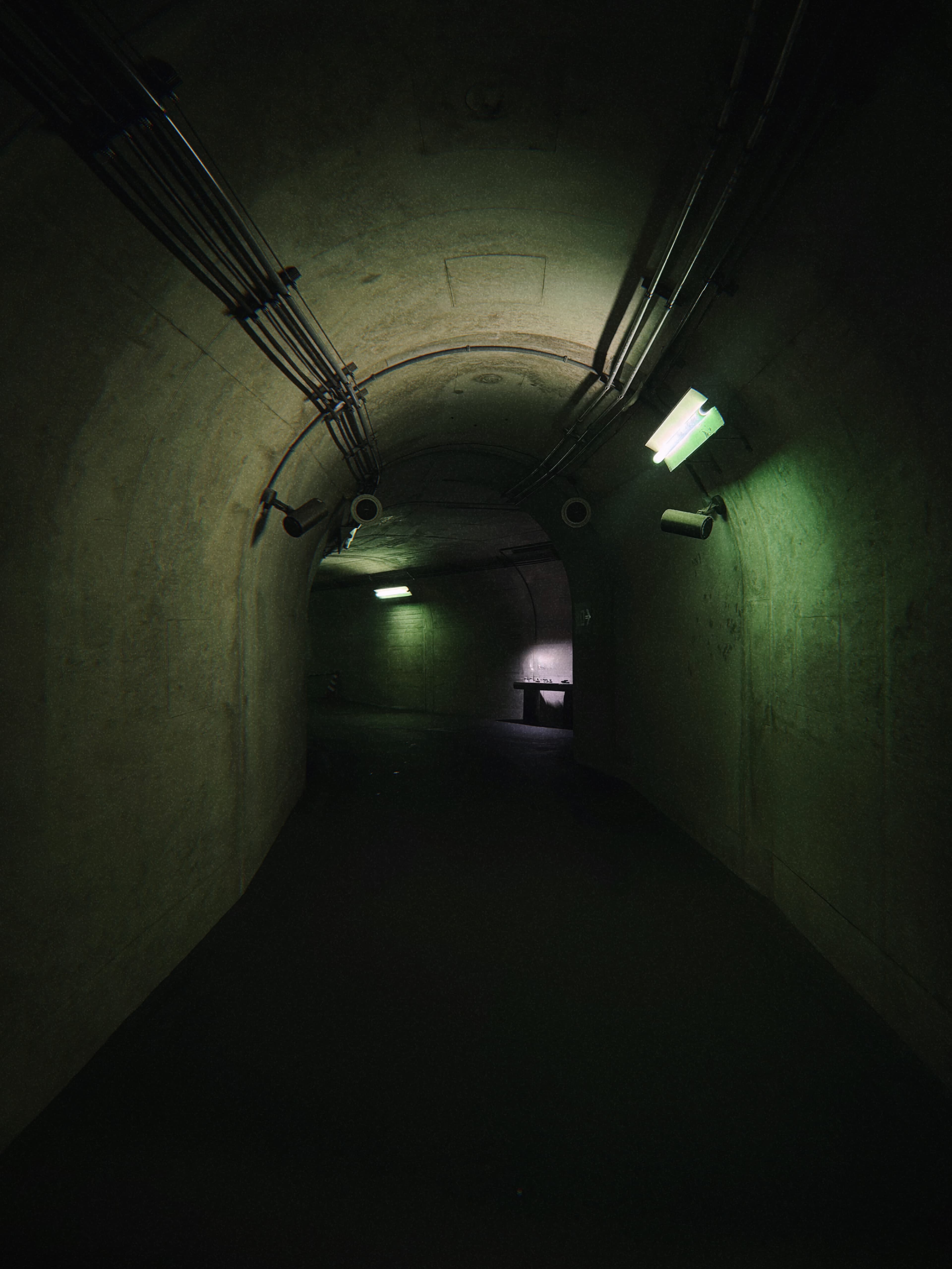 A green-lit concrete tunnel